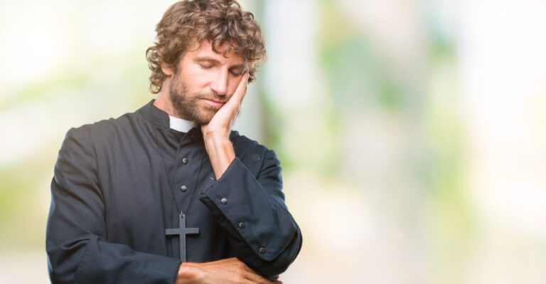 A pastor in a black clerical robe with a white collar and cross necklace stands with one hand on his cheek, appearing thoughtful against a blurred green and white background. His serene demeanor suggests he's contemplating how to avoid burnout in his demanding role.