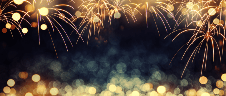 A festive scene with golden fireworks illuminating the night sky in 2023. The blurred background features shimmering bokeh lights in shades of gold and teal, crafting a vibrant and celebratory atmosphere that feels better than ever.