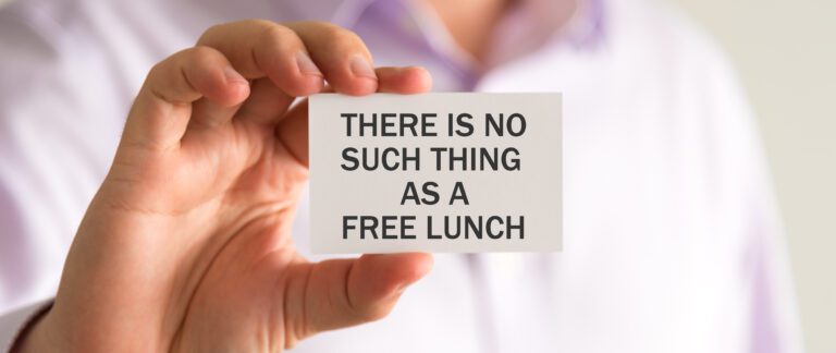 A person in a white shirt is holding a card with the text "THERE IS NO SUCH THING AS A FREE LUNCH," a stark reminder amidst conversations about free services and paid services.