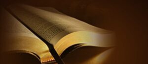 A partially open book with its pages spread, illuminated by warm, soft lighting against a dark background. The focus is on the edges of the pages, creating a serene and contemplative atmosphere—reminiscent of moments reflecting on heartfelt reasons for pastor appreciation.