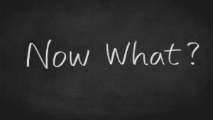 White chalk text on a blackboard reads "Now What?" suggesting post-Easter events and holiday planning are next.
