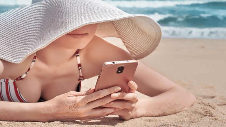 A woman in a striped bikini lies on the sandy beach, streaming her favorite playlist from a smartphone. She is wearing a large, floppy sun hat that partially shades her face, prioritizing comfort and style. The ocean waves are visible in the summertime background.