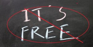 A chalkboard displays the words "It's free," but a bold red circle with a diagonal line strikes through it, emphasizing that it's not always free.