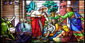 A vibrant stained glass window in a digital ministry setting depicts a bearded man in a white robe with a red cloak, gently lifting a child surrounded by onlookers. The background features trees and buildings, conveying compassion and aid. This inspiring image has the potential to go viral.